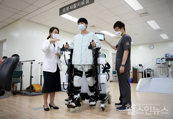 유지현 일산백병원 재활의학과 교수(왼쪽)가 재활 로봇을 활용한 로봇보조 보행 치료 방법을 설명하고 있다.
