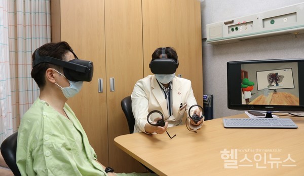 삼성서울병원 암병원 간암센터 유진수 교수가 VR 기기를 이용하여 환자에게 수술 설명을 진행하고 있다