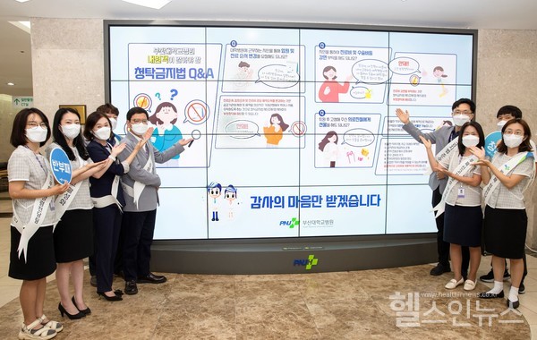 부산대병원 외래센터 미디어월 앞에서 감사실 직원들이  클린 캠페인을 진행하고 있다.