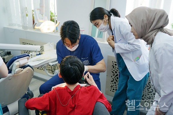 서울대치과병원 의료 봉사단이 우즈베키스탄에서 어린이 환자를 진료하고 있다.